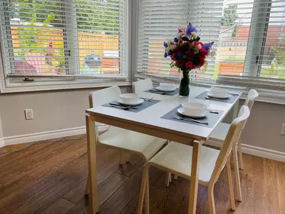 a dining room table with chairs and a vase of flowers at MT house in Mississauga