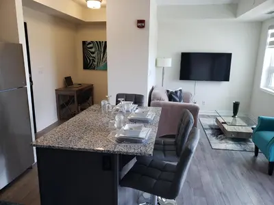 a living room with a table and a couch at Luxurious Condo Apartment 2BRs-1BAs-1Office with free parking in Brampton