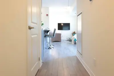 a hallway with a room with a desk and a chair at Luxurious Condo Apartment 1BR-1BA-1Office free parking in Brampton