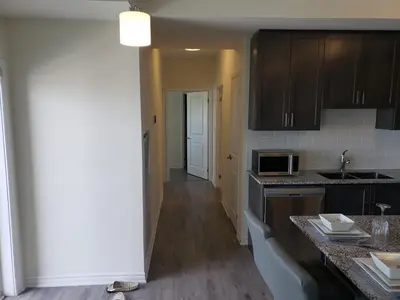 a kitchen with black cabinets and a counter top at Luxurious Condo Apartment 1BR-1BA-1Office free parking in Brampton