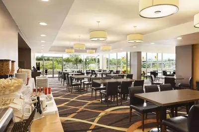 a restaurant with tables and chairs and windows at Travelodge by Wyndham Niagara Falls Fallsview in Niagara Falls