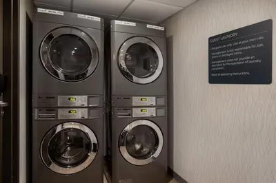 three washing machines in a room with a sign at Holiday Inn Hotel & Suites St.Catharines-Niagara by IHG in St. Catharines