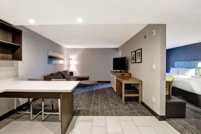 a hotel room with a bed and a living room at Hampton Inn St. Catharines Niagara in St. Catharines