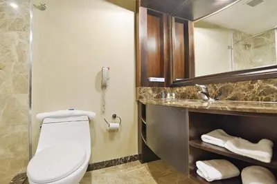 a bathroom with a toilet and a phone at Woodbine Hotel & Suites in Toronto