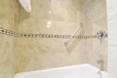 a bathroom with a shower with a toilet in it at Woodbine Hotel & Suites in Toronto