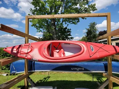 a red kayak sitting on top of a fence at Fun Place with a Sandy Beach for Swimming, Boating & Fishing, Featuring 1 House and 3 Cabins in Fenelon Falls