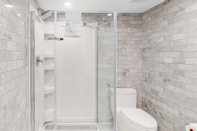 a white bathroom with a shower and a toilet at Wintergreen 119 in Blue Mountains