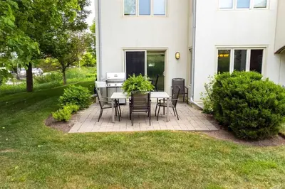 a patio with a table and chairs in front of a house at Luxurious Blue Mountain 3BR & 3BTH Walk-in to Village in Blue Mountains