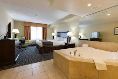 a hotel room with a tub and a bed at Country Inn & Suites by Radisson, Niagara Falls, ON in Niagara Falls