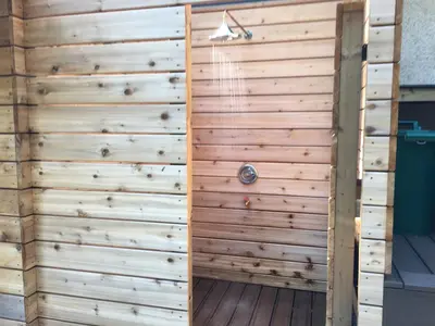 a wooden wall in a room with a wooden door at Stunning Modern Beach House with Swimming Pool and Spectacular Sunsets in Tiny