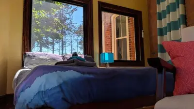 a bedroom with a blue bed with a window at The Front Porch Room of a 140-Year-Old Victorian House in Orangeville