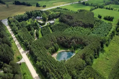 an aerial view of a lake in a forest at A charming, rustic 150 year old Carriage House in Orangeville