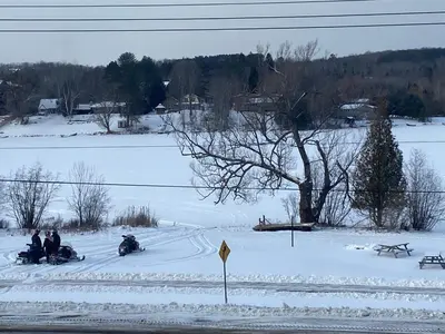 a group of people riding on snowboards in the snow at Silver Maple Motel in Haliburton