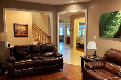 a living room with a leather chair and a couch at Aurora Executive Upscale Residence Three Bedrooms Three and Half Bathrooms in Aurora