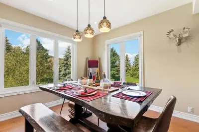 a dining room with a table and chairs and windows at Luxurious Sierra Lane Escape in Blue Mountains