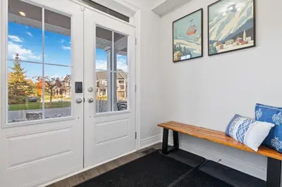 a door in a room with a bench and windows at Modern home with a pool sauna pooltable & mountain view in Collingwood