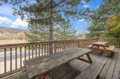 a wooden bench sitting on a wooden deck at 12 Beds Sleep 16 Chalet with HotTub, 2min to Blue in Blue Mountains
