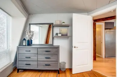a bedroom with a dresser and a mirror at The Beehive w Hot Tub Sauna & Fireplace in Blue Mountains