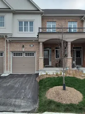 a house with a tree in the front yard at Close Property in Bowmanville