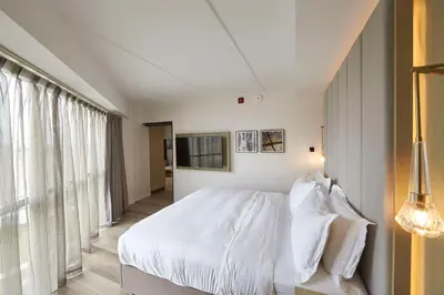 a bedroom with a white bed and a large window at Bloom Mississauga, Tapestry Collection By Hilton in Mississauga