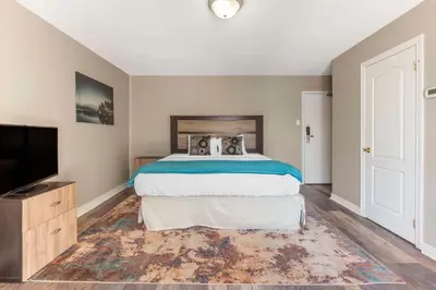 a bedroom with a bed and a flat screen tv at Christie's Mill Inn & Spa - BW Premier Collection in Port Severn