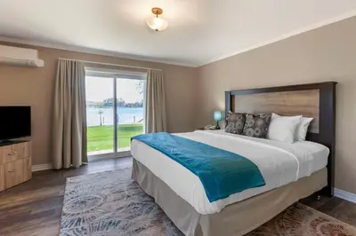 a bedroom with a large bed and a large window at Christie's Mill Inn & Spa - BW Premier Collection in Port Severn