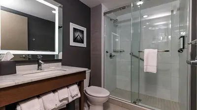 a bathroom with a shower and a toilet and a sink at Hyatt Place Toronto-Brampton in Brampton