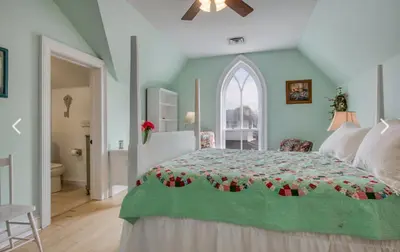 a bedroom with a bed with a green comforter at Bristows Inn in Elmira