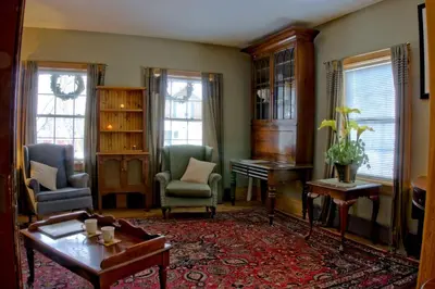 a living room with a table and chairs and a piano at Emilyville Inn in Campbellford