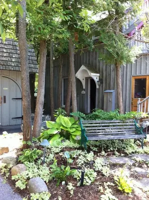 a park bench sitting in front of a house at Windswept on the Trent in Campbellford