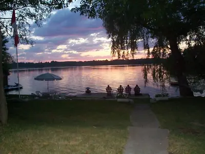 a view of a lake with a table and an umbrella at Windswept on the Trent in Campbellford