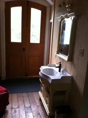 a bathroom with a sink and a mirror and a door at Windswept on the Trent in Campbellford