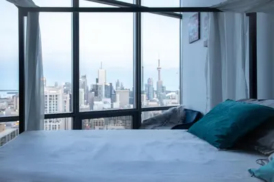 a bedroom with a bed with a view of the city at Urban Skyline in Toronto