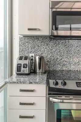 a kitchen with a counter with a toaster and a microwave at Urban Skyline in Toronto