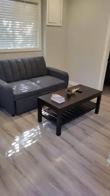 a living room with a black couch and a coffee table at Wasaga Beach Loft 4 in Wasaga Beach