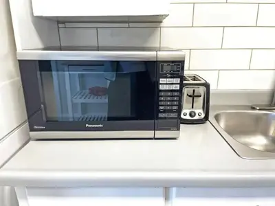 a microwave oven sitting on a counter in a kitchen at Hamilton Chic Retreat - Comfy Beds - Garden - Pool in Hamilton