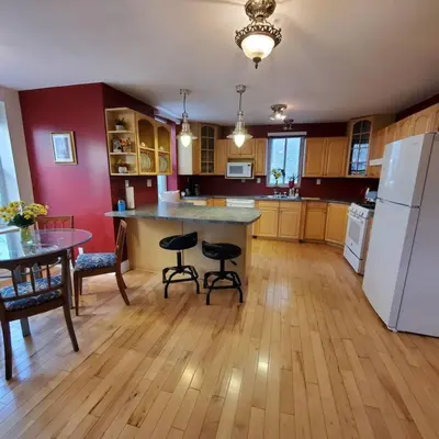 a large kitchen with a table and a refrigerator at Garden 2 Storey House in Niagara Falls