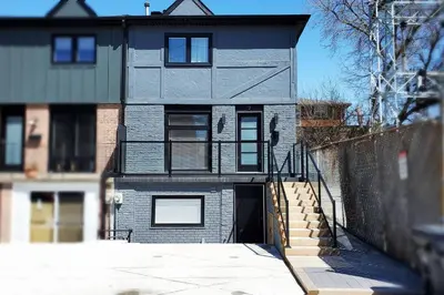a gray house with a fence in front of it at Renovated Guest Suite Near The Lake & High Park in Toronto! in Toronto