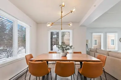 a dining room with a table and chairs and a couch at Mountain Walk Chalet Across From Blue Mtn Village in Blue Mountains