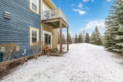 a house with a balcony on the side of it at Blue Mtn Getaway in Historic Snowbridge Chalet in Collingwood