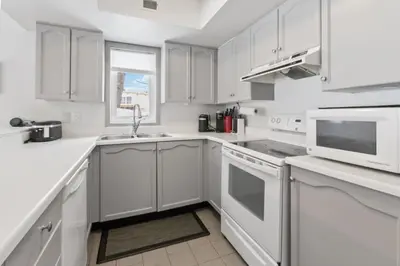 a white kitchen with white appliances and a window at Condo With Blue Mtn Village In Your Backyard in Blue Mountains