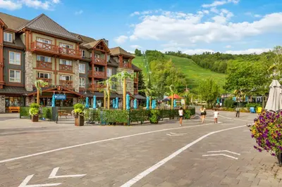 a group of people walking in a plaza in front of a building at Condo With Blue Mtn Village In Your Backyard in Blue Mountains