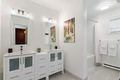 a white bathroom with two sinks and a shower at Luxury Blue Mtn Getaway w Indoor Sauna in Blue Mountains