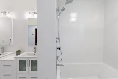 a white bathroom with a shower and a sink at Luxury Blue Mtn Getaway w Indoor Sauna in Blue Mountains