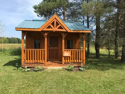 a wooden cabin in the middle of a field at Dreamers Writing Farm, 3 Wooded Acres, Hepworth in Sauble Beach