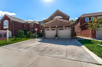 a house with two garage doors on a driveway at Home Stay near the Airport in Mississauga