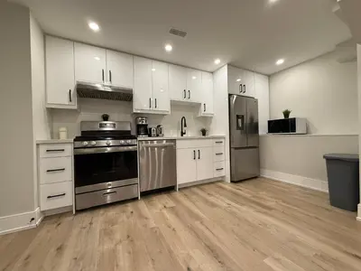 a kitchen with white cabinets and stainless steel appliances at Modern 1BR - Heart of Queen West in Toronto