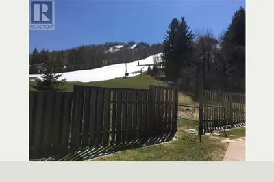 a fence in front of a hill with a ski slope at Freshly Upgraded Cozy Loft @ North Creek Resort in Blue Mountains