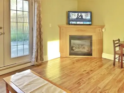 a living room with a fireplace and a flat screen tv at Sunny Motel Port Elgin in Port Elgin
