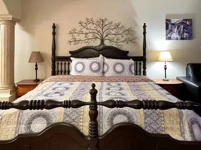 a bedroom with a large bed with a tree on the wall at Sunny Motel Port Elgin in Port Elgin